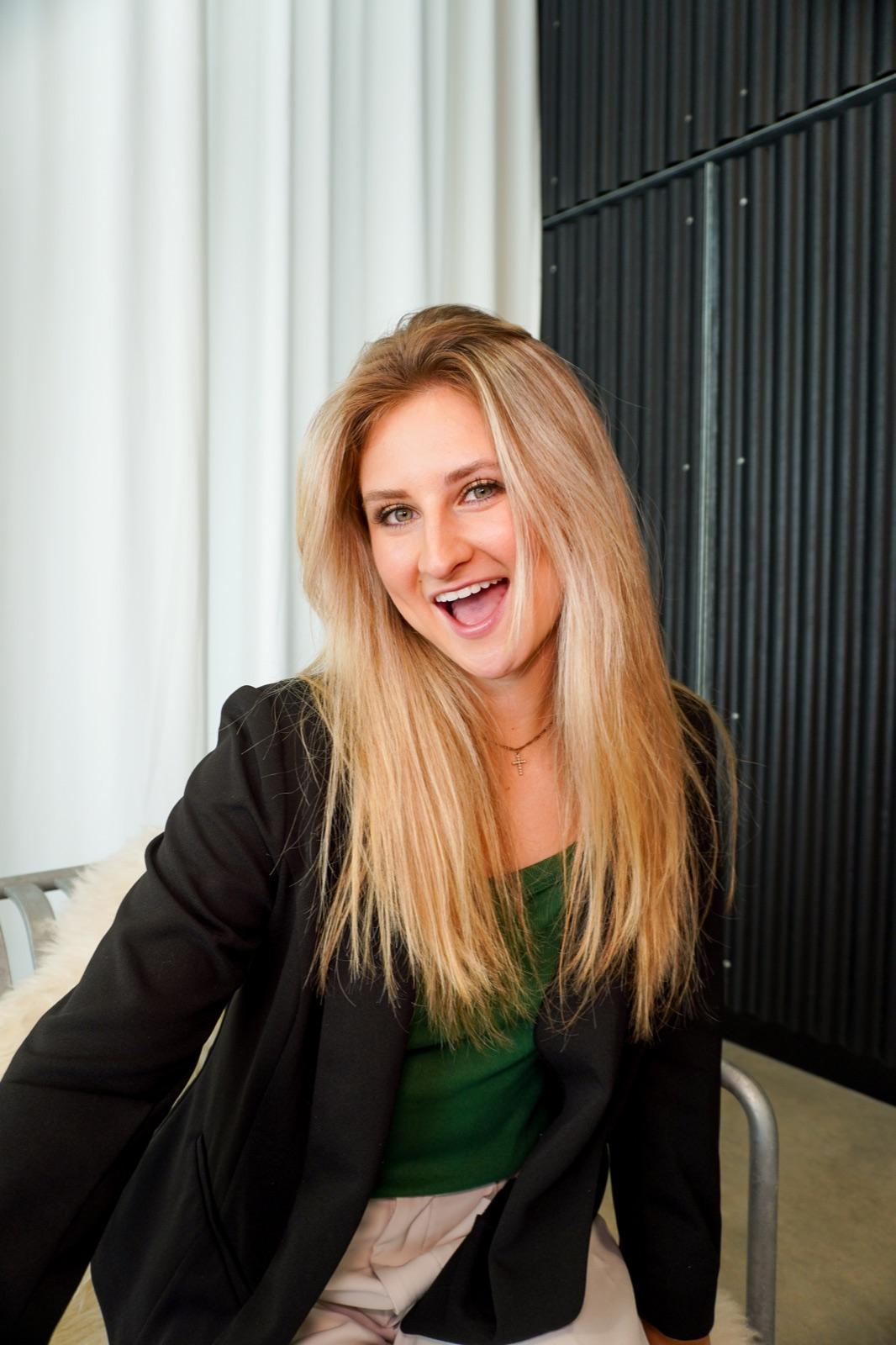 Abigail Rowland laughing, seated in a black blazer